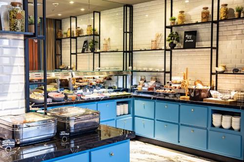 a kitchen with blue cabinets and food on display at Courtyard by Marriott Sarajevo in Sarajevo