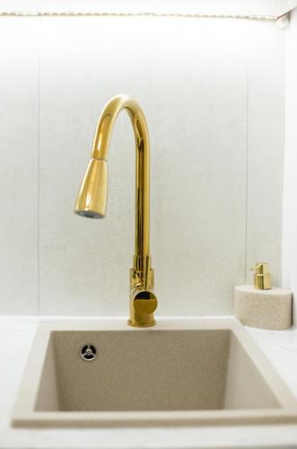 a sink with a gold faucet on top of it at Monjan II Luxury Square Market Rynek in Wrocław