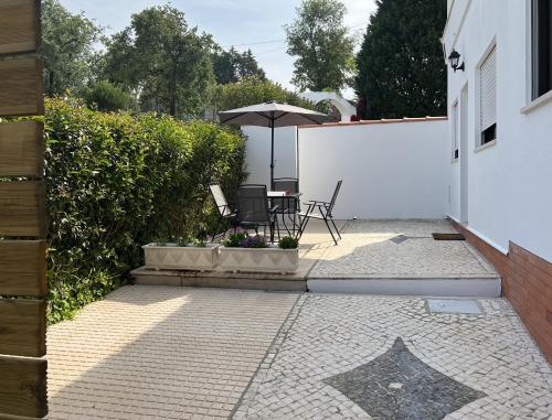 a patio with a table and an umbrella at Farm stay in Maceira, Leiria 