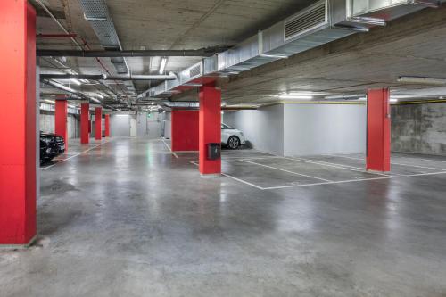 an empty parking lot with red columns in a parking garage at B&B HOTEL Zaragoza Plaza Mozart in Zaragoza