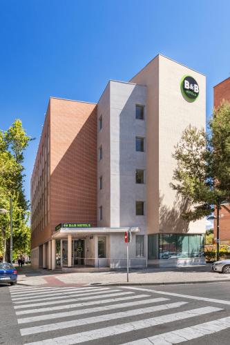 a building on a street with a crosswalk in front of it at B&B HOTEL Zaragoza Plaza Mozart in Zaragoza