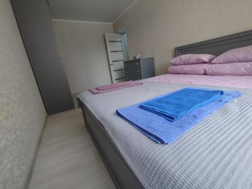 Una cama con toallas rosas y azules. en Апартаменты рядом с морем, en Sukhumi
