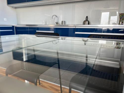 uma mesa de vidro numa cozinha com um lavatório em Do Gdyni Exclusive em Gdynia
