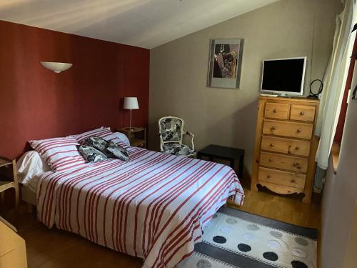 une chambre avec un lit et une commode avec une télévision dans l'établissement Chez Marie, à Sérignan-du-Comtat