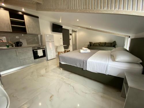 a bedroom with a large bed and a kitchen at Hotel Almira in Agia Triada