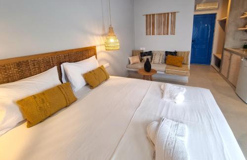 1 cama blanca grande con almohadas amarillas en una habitación en Artemis en Makry Gialos