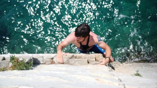 a man in a tank top sitting on a wall at AI HOSTEL in Split