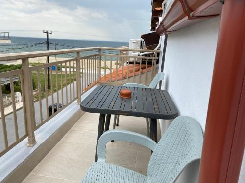 a table and chairs on a balcony with the ocean at Hotel Almira in Agia Triada