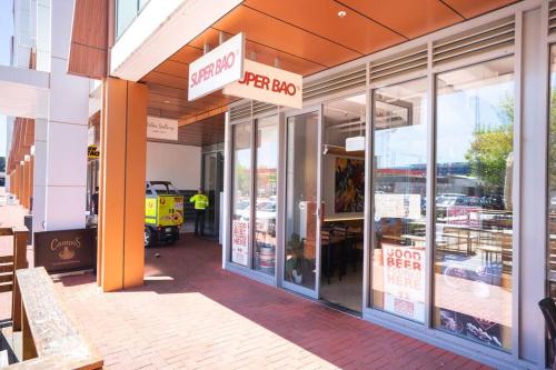 a store front with a sign for a store at Lux 2 Bed 2 Bath Secure Parking Apartment in the Heart of Dickson, Canberra in Canberra