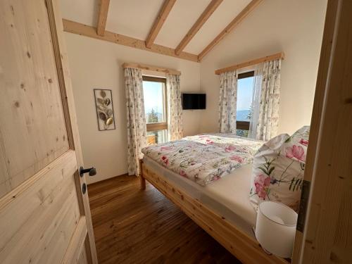 a bedroom with a bed and two windows at Berglisl - direkt an der Schipiste! Neue Ferienwohnung mit Sauna in Klippitztorl
