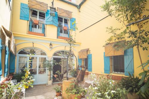 een geel en blauw gebouw met planten ervoor bij La Casa 1832 Boutique in Sanlúcar de Barrameda