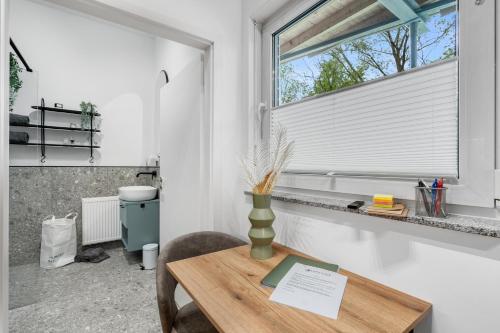 einen Tisch mit Vase in einem Zimmer mit Fenster in der Unterkunft Apartment klein aber fein in Friedrichshafen in Friedrichshafen