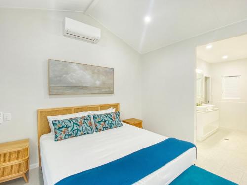 a white bedroom with a bed and a bathroom at Rock Salt Villa 2 in Picnic Bay
