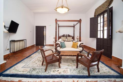 uma sala de estar com uma mesa e cadeiras e uma televisão em La Casa 1832 Boutique em Sanlúcar de Barrameda