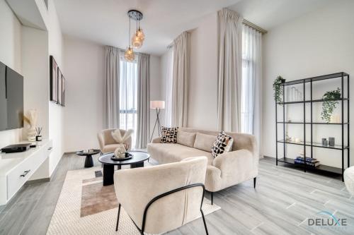 a living room with a couch and a table at Placid 2BR with Assistant Room at Mesk 1 Midtown Dubai Production City by Deluxe Holiday Homes in Dubai