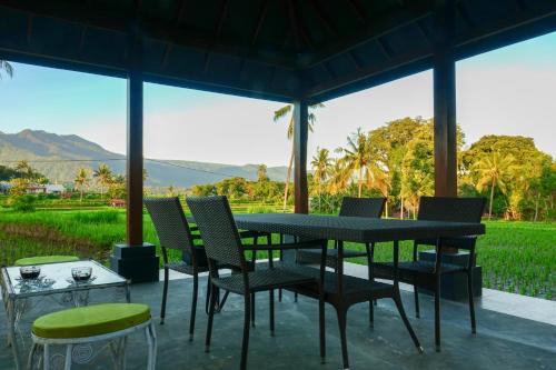 a table and chairs on a patio with a view at Gubuk Kurnia in Sawan