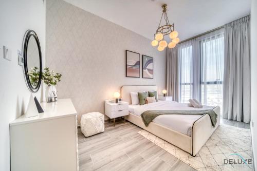 a white bedroom with a bed and a mirror at Placid 2BR with Assistant Room at Mesk 1 Midtown Dubai Production City by Deluxe Holiday Homes in Dubai