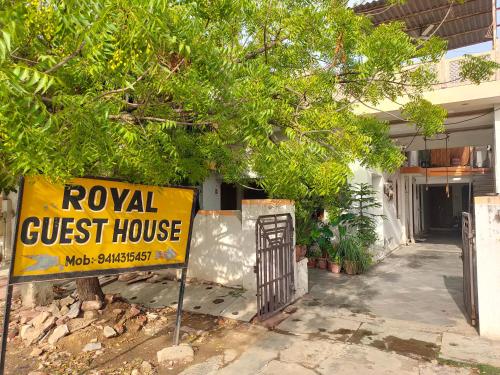 a yellow guest house sign in front of a house at Royal Guest House in Bharatpur
