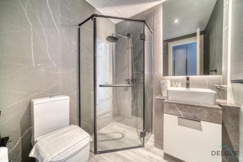 a bathroom with a shower and a toilet and a sink at Placid 2BR with Assistant Room at Mesk 1 Midtown Dubai Production City by Deluxe Holiday Homes in Dubai
