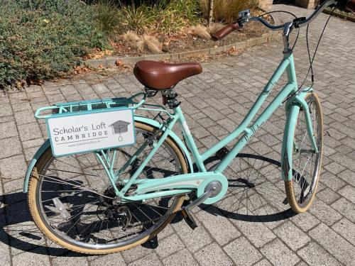una bicicleta estacionada en una acera con un cartel en ella en Scholar's Loft - Cosy & Close to Central Cambridge en Cambridge