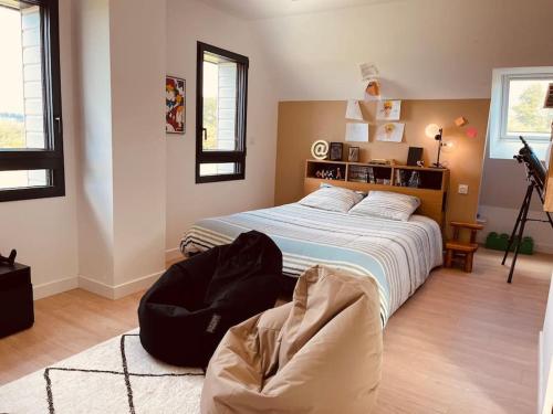 1 dormitorio con 1 cama y 1 silla en Villa avec piscine, vue mer et campagne., en Bonneville-sur-Touques