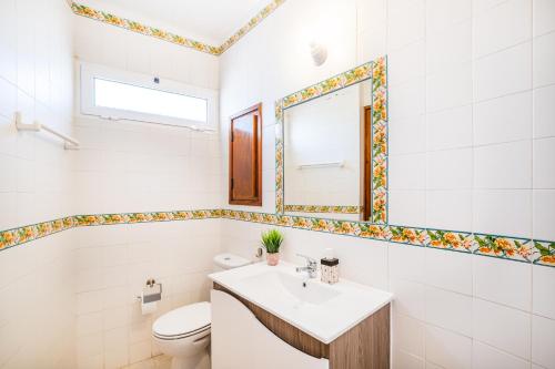 La salle de bains est pourvue d'un lavabo, de toilettes et d'un miroir. dans l'établissement Entire Apartment 5min from Oura Beach, à Albufeira