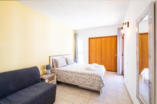 a small bedroom with a bed and a couch at Entire Apartment 5min from Oura Beach in Albufeira