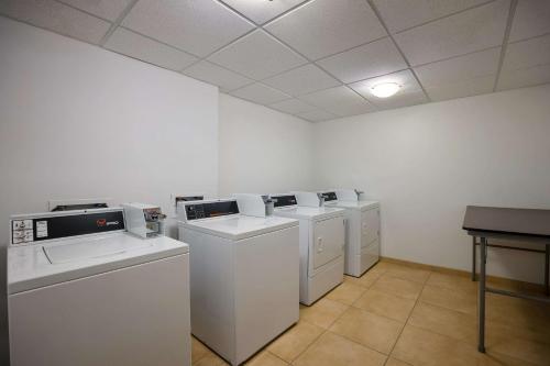 una lavandería con máquinas blancas y una mesa en Sleep Inn & Suites, en Colby