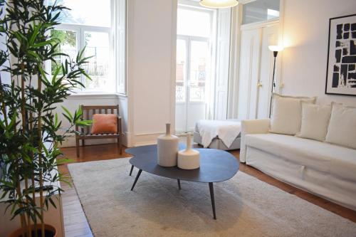 een woonkamer met een witte bank en een tafel bij The Residences at Bairro Alto in Lissabon
