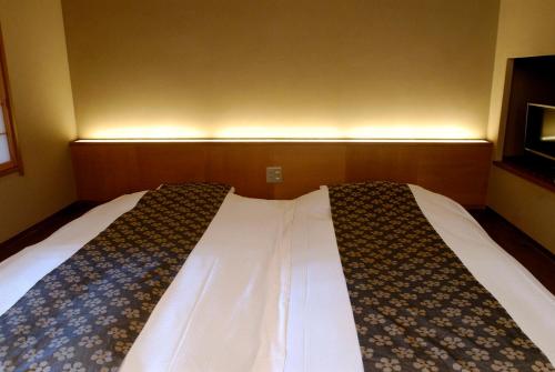 a bed in a small room with at Ryokan Sumiya Kihoan in Kameoka