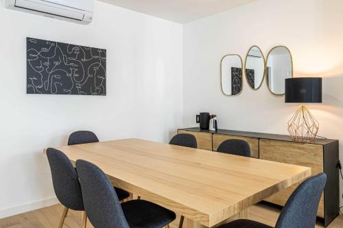 een eetkamer met een houten tafel en stoelen bij Superb 90m2 apartment in the heart of Cannes - rue d'Antibes in Cannes