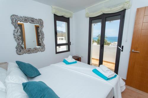 1 Schlafzimmer mit 2 Betten und einem Wandspiegel in der Unterkunft Casa del Mar in Mojácar