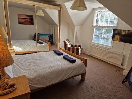 a hotel room with a bed and a mirror at Looe Spacious 4 Double bedroom House Sleeps 9 Harbour River Views in Looe