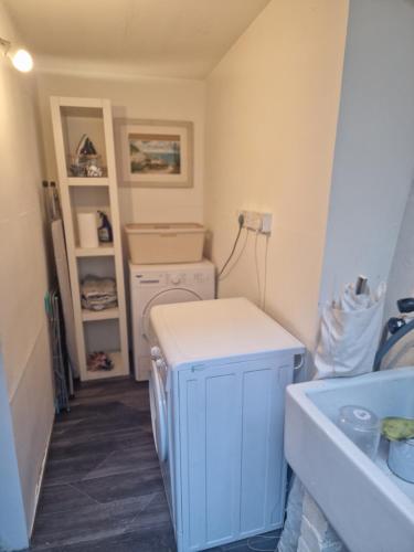 a small laundry room with a washer and dryer at Looe Spacious 4 Double bedroom House Sleeps 9 Harbour River Views in Looe