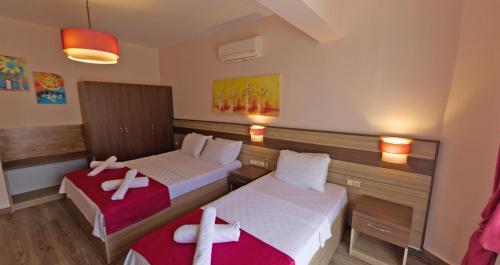a hotel room with two beds with towels on them at Eden Pyara Hotel Turunc in Turunc