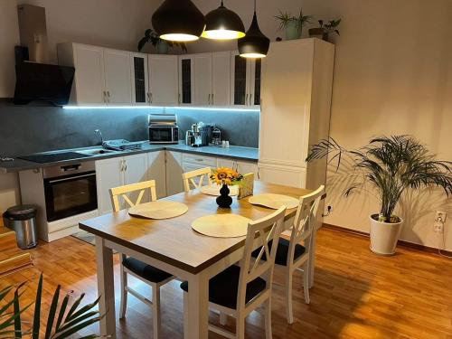 uma cozinha com uma mesa de madeira e cadeiras num quarto em Villa Monica em Kráľovský Chlmec