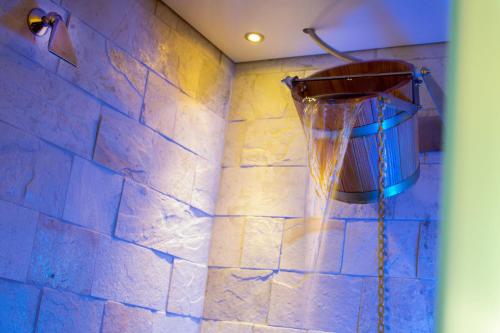 a shower with a bucket on the wall at Wellness- und Schneesporthotel Christiania in Saas-Almagell