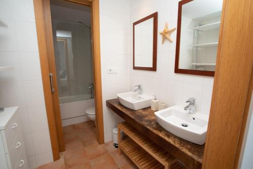 een badkamer met 2 wastafels, een spiegel en een toilet bij Casa del Mar in Mojácar