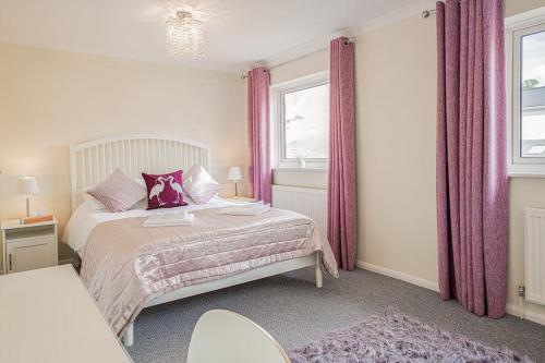 a bedroom with a large bed with purple curtains at Central 2 Bed House w/ Garden and Free Parking! in Cheltenham
