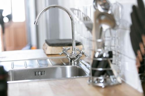 a kitchen sink with a faucet on a counter at Peaceful Apartment - Dedicated Free Parking - Walk to Centre, Uni, Hosp - Business and Leisure - Contact For Long Stays in Exeter