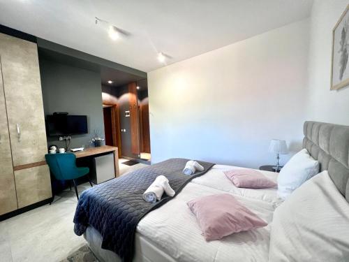 a bedroom with a bed with two pillows and a desk at ELFF -Apartamenty i pokoje gościnne in Cisna