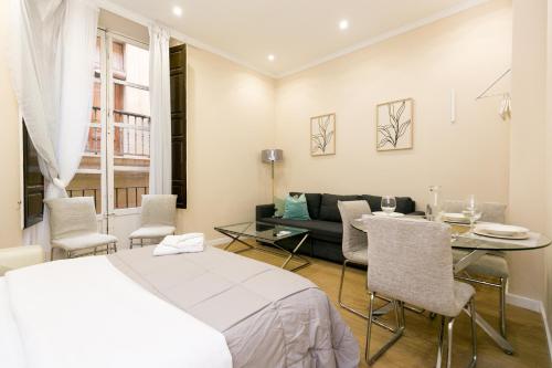 Un dormitorio con una cama, una mesa y un sofá. en Navitour Santa Ana, en Granada