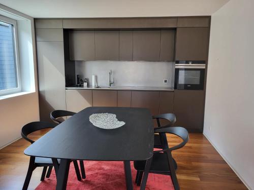 a black table and chairs in a kitchen at Les Cubes in Martigny-Ville