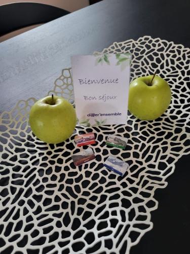 two green apples sitting on a table with a sign at Les Cubes in Martigny-Ville