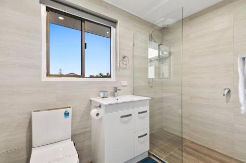 ein Bad mit einem WC, einem Waschbecken und einem Fenster in der Unterkunft Moreton Views! in Beachmere