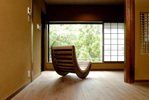 a chair sitting in a room with a large window at Ryokan Sumiya Kihoan in Kameoka