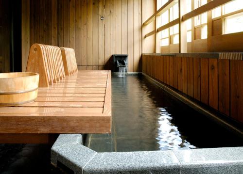 a pool of water in a room with a wooden table at Ryokan Sumiya Kihoan in Kameoka