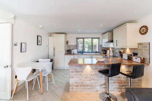 a kitchen with a counter and a table and chairs at 1 The Cottage in Upholland