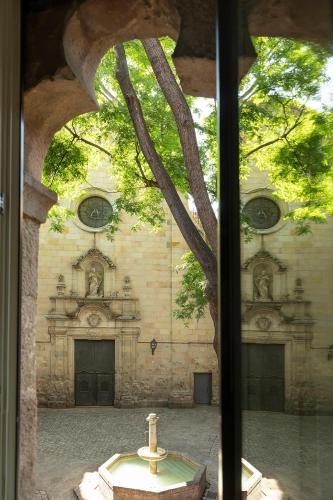 a view of a church from a window with a cross at Hotel Neri – Relais & Chateaux in Barcelona