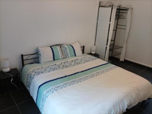a bedroom with a bed with blue and white sheets at O'Couvent - Appartement 522 - 2 chambres - 85 m2 - Deuxième étage in Salins-les-Bains
